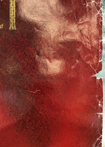 A close-up of a textured red surface with a vertical metallic silver edge and a small gold decorative element at the top left.