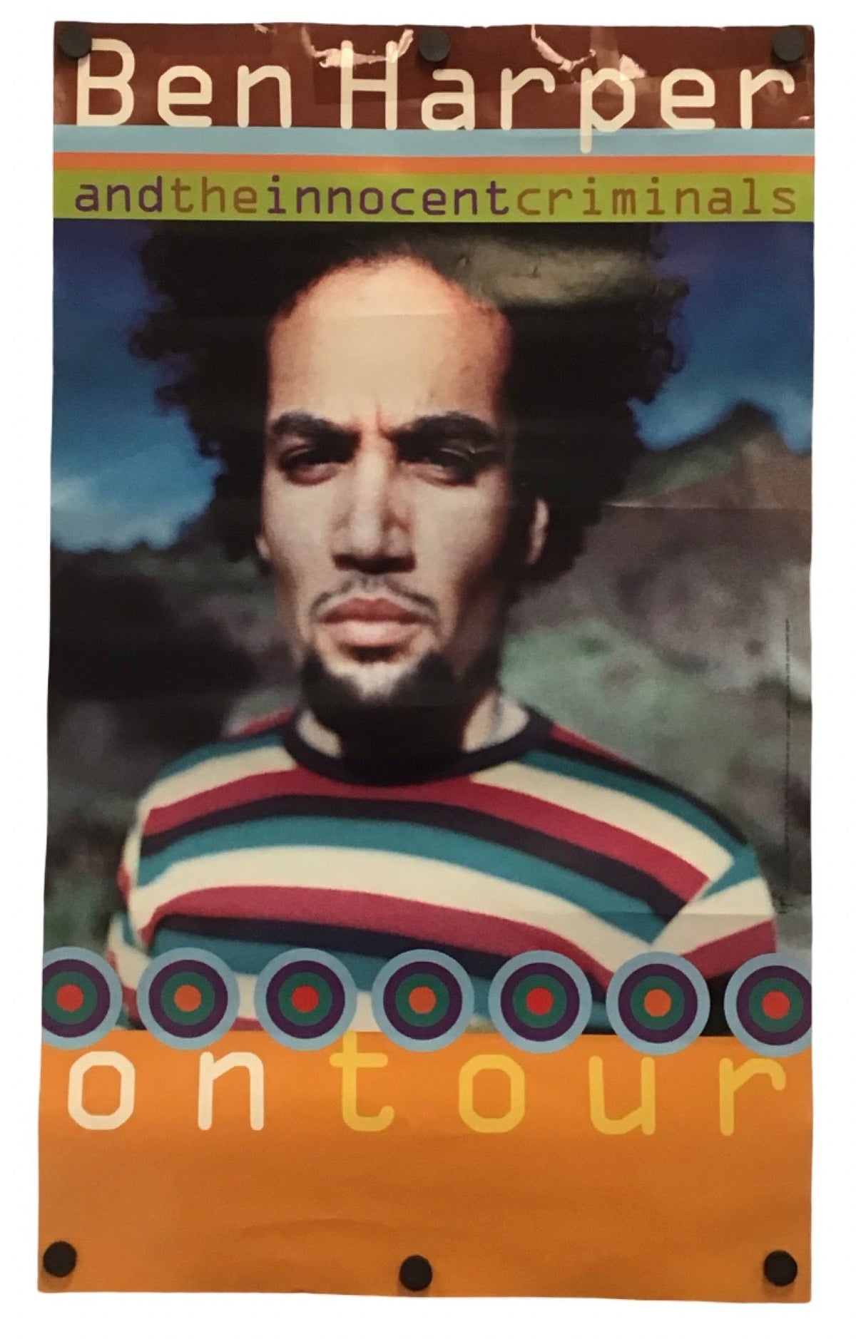 A vertical printed banner or flag featuring a portrait of Ben Harper with the text 'Ben Harper and the innocent criminals' and 'ontour', with an orange border and metal grommets at the bottom, shown against a plain white background.