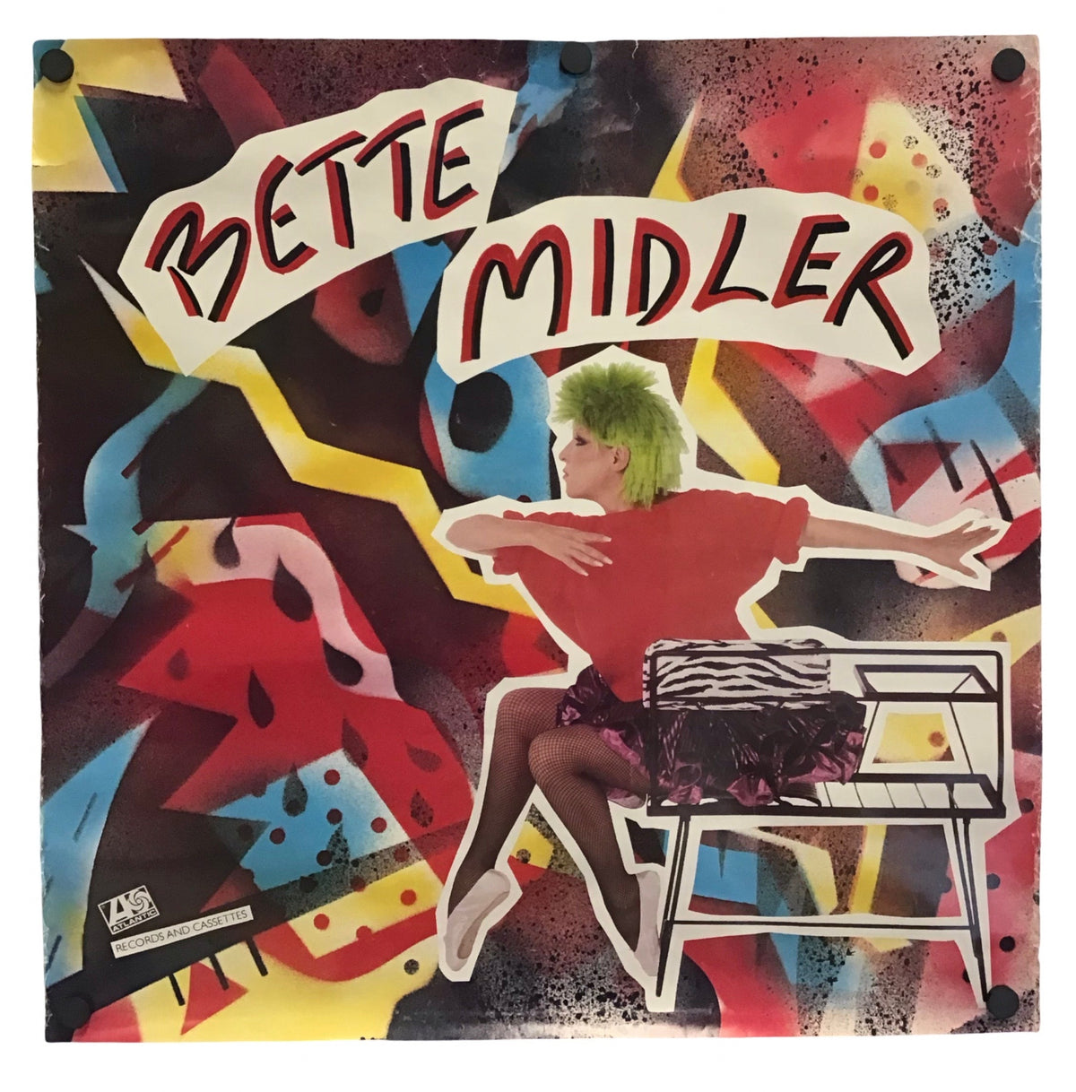 A square wall art print featuring a colorful collage-style illustration with the text 'BETTE MIDLER' across the top, showing a seated figure, abstract shapes, and bold red, yellow, black, blue, and white tones.