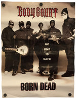 A printed poster or banner featuring the band Body Count with the text 'Body Count' at the top and 'Born Dead' at the bottom. The central printed photo shows several masked figures in dark clothing, with one kneeling figure in the middle wearing a shirt that reads 'NO ONE IS SAFE'.
