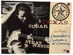 A signed collectible poster of Chris Duarte Group's 'Strat Magik' album featuring a black and white photo of Chris Duarte playing an electric guitar, alongside a beige section with handwritten blue ink writing and a circular 'Chris Duarte Group' logo.