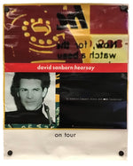 A vintage concert poster for David Sanborn 'Hearsay' on tour, featuring a collage design with a portrait, a red banner, and a black background, displayed on a white sheet with binder clips.
