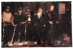 A rectangular Duran Duran band poster featuring a group photo of the five members in dark outfits, with the Duran Duran logo in the top right corner, shown against a plain white background.