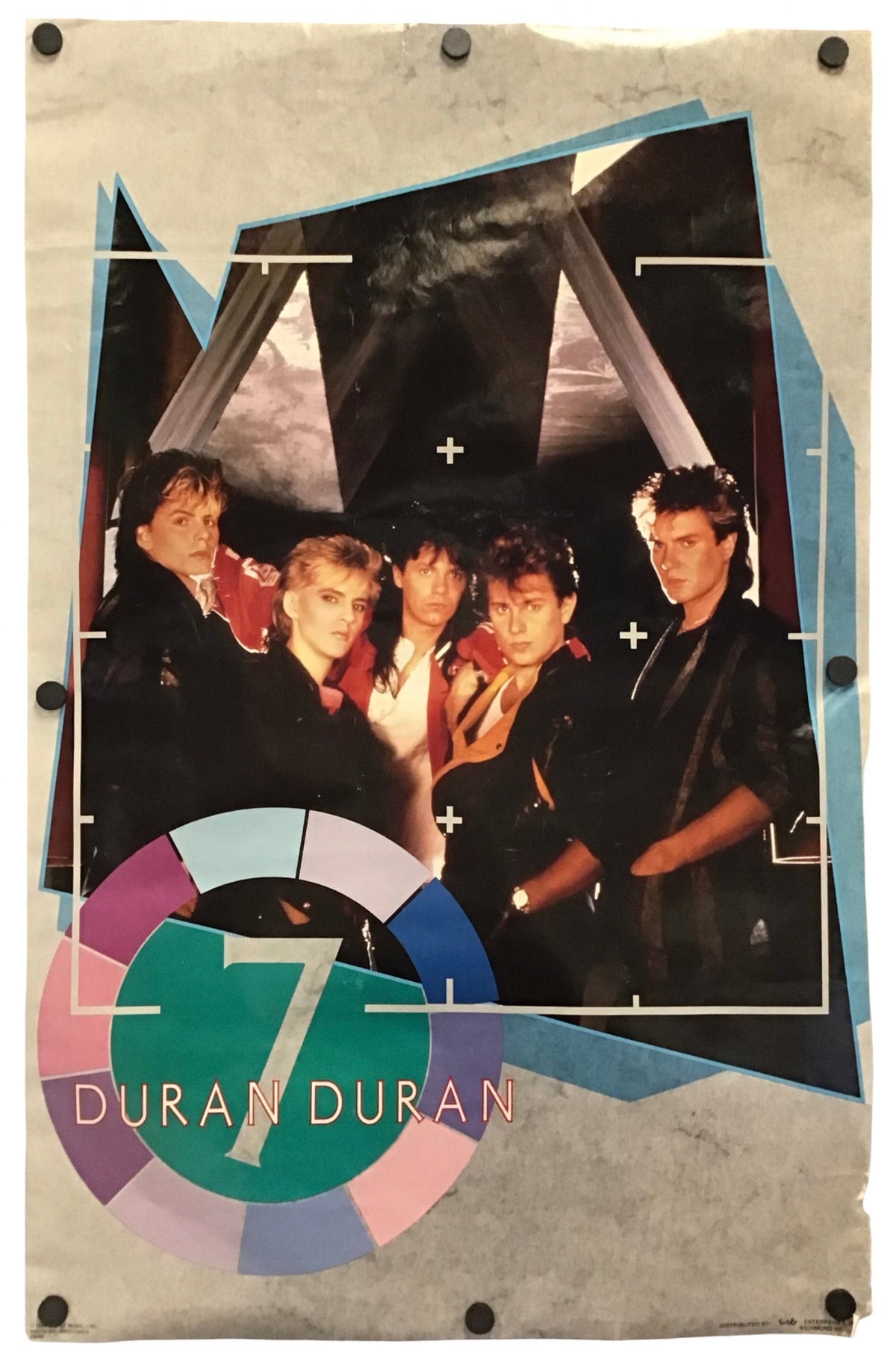A vintage-style poster or print featuring a group photo of the band Duran Duran, with a large colorful '7' and 'DURAN DURAN' logo at the bottom. The print has a distressed, scrapbook-like border with pins around the edges and is photographed against a plain white background.