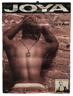 A rectangular poster or print featuring the album cover art for Joya's 'Here I Am', showing a shirtless person from behind against a brick wall, with the text 'JOYA' at the top and 'Here I Am' on the right.