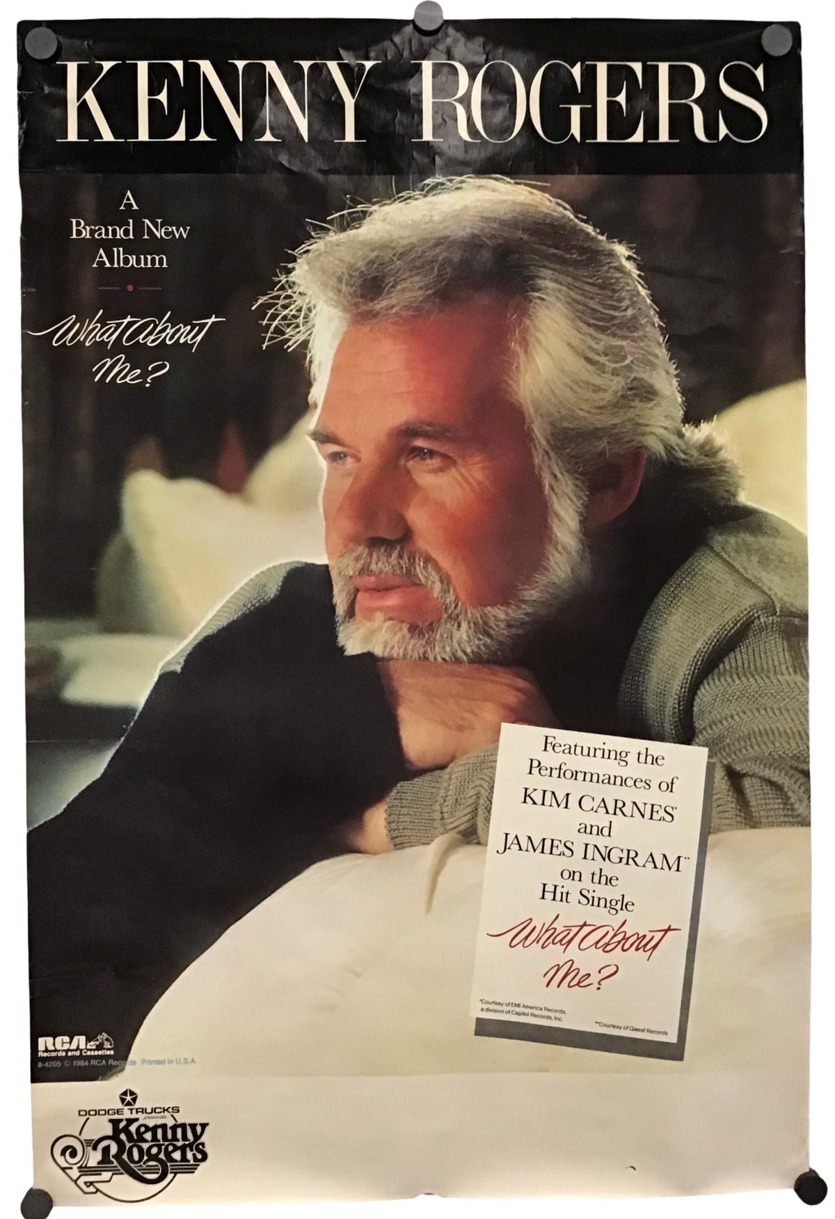 A vintage Kenny Rogers album poster for 'What About Me?' featuring a portrait of the artist, with text and a small printed insert card, photographed against a light neutral background.