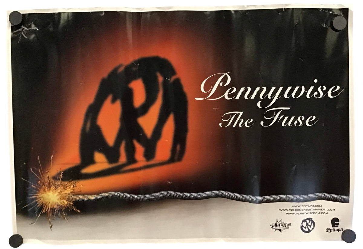 A vintage promo poster for 'Pennywise The Fuse' featuring a black silhouette of two figures against a fiery orange and red gradient background, with the title in white script. The poster is displayed hanging on a white wall with black binder clips at the corners.