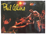 A vintage concert poster for Phil Collins featuring a live performance scene with stage lights, clapping audience members, and the artist on stage. The name 'Phil Collins' is written in large yellow script across the top left.