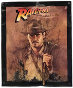 A Raiders of the Lost Ark poster featuring a stylized illustration of Indiana Jones, with the movie title at the top and a black border around the print.