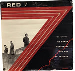A square vinyl record sleeve for the band Red 7, featuring a black background with bold red graphic stripes, a sepia-toned photo of three men standing on a wall, and white text listing featured songs.