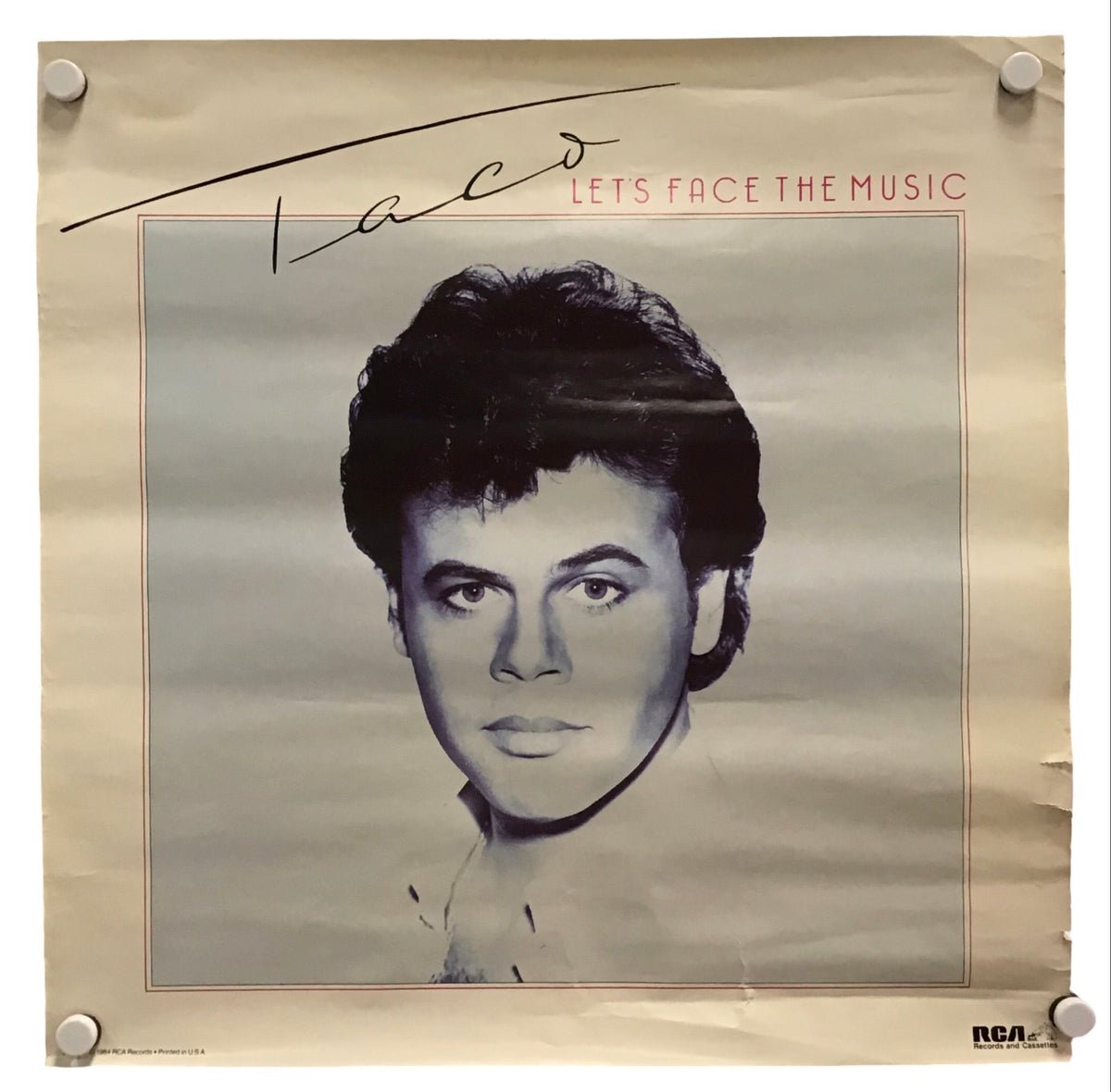 A vintage-style poster or print featuring a black-and-white portrait of a man with the text 'Laco' and 'LET'S FACE THE MUSIC' on a beige background, photographed against a white backdrop with visible mounting clips at the corners.