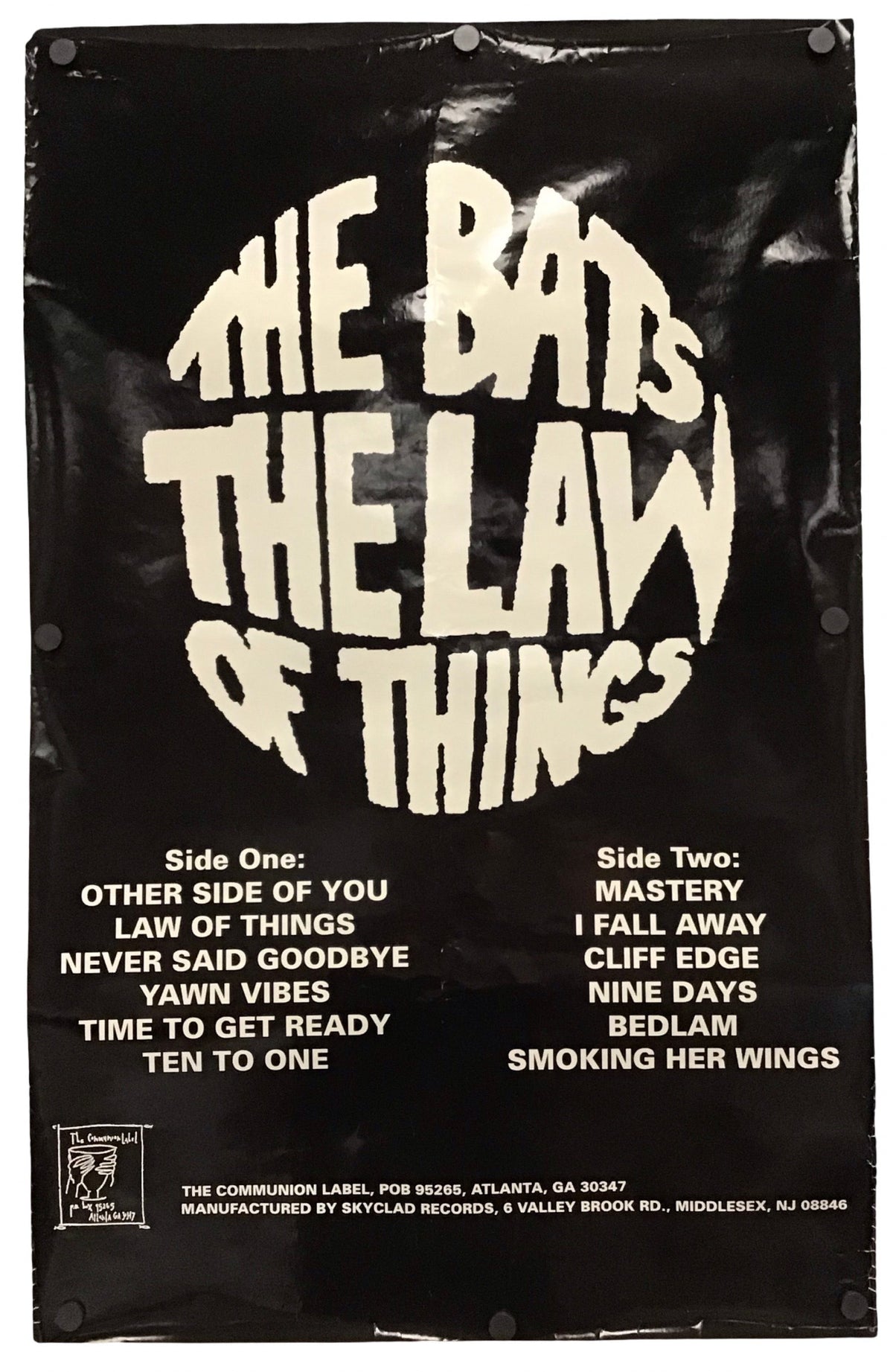 A black vinyl music poster for the band 'The Bats - The Law of Things' featuring large cream-colored stylized text and track listings for Side One and Side Two, photographed against a white background.