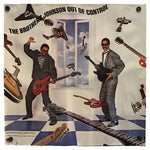 A vintage-style poster print featuring a surreal collage with two men in suits playing electric guitars in front of a window, surrounded by floating guitars and instruments. The text at the top reads 'THE BROTHERS JOHNSON OUT OF CONTROL.