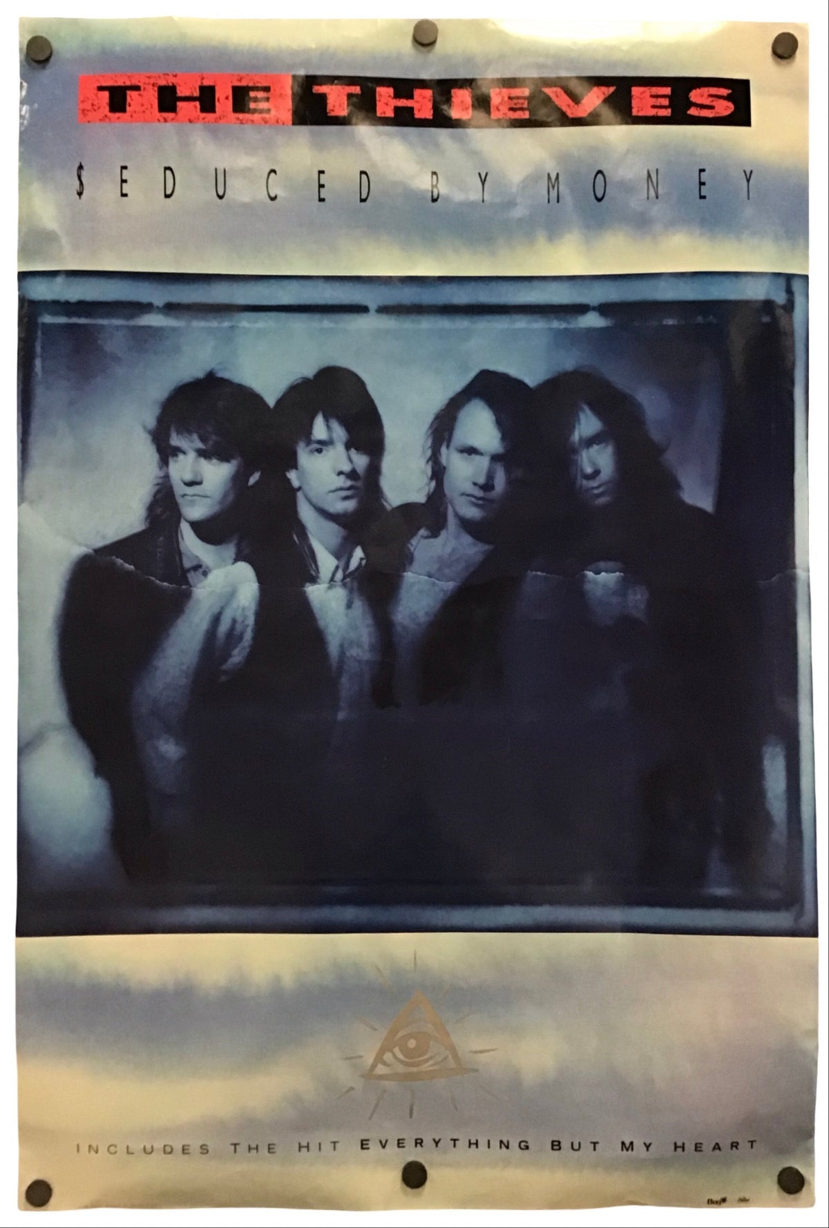A vintage-style band poster for The Thieves, 'Seduced by Money,' featuring a blue-toned photo of the four band members, with the band name in red and black at the top and a beige smoky border around the design.