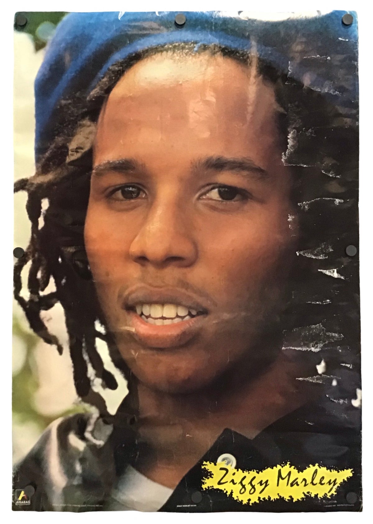 A vintage-style poster or print featuring a close-up portrait of Ziggy Marley, with a blue head covering and black clothing, shown against a white background.