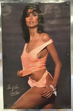 A signed photo print of model Carol Alt wearing a peach-colored bikini top and matching bottoms, displayed on a metallic surface with binder clips.