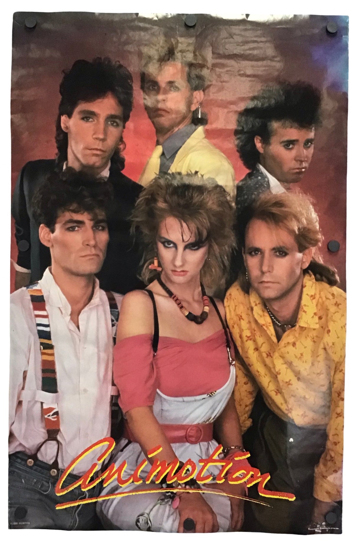 A vintage-style poster or print featuring five people posed together against a textured reddish-brown background, with the word 'Animotion' in large stylized lettering at the bottom. The print is photographed hanging against a plain white wall.