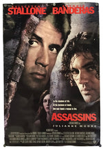 A vertical movie poster for the film 'Assassins' featuring close-up portraits of Sylvester Stallone and Antonio Banderas, with Julianne Moore at the bottom, red title text, and a dark textured background.