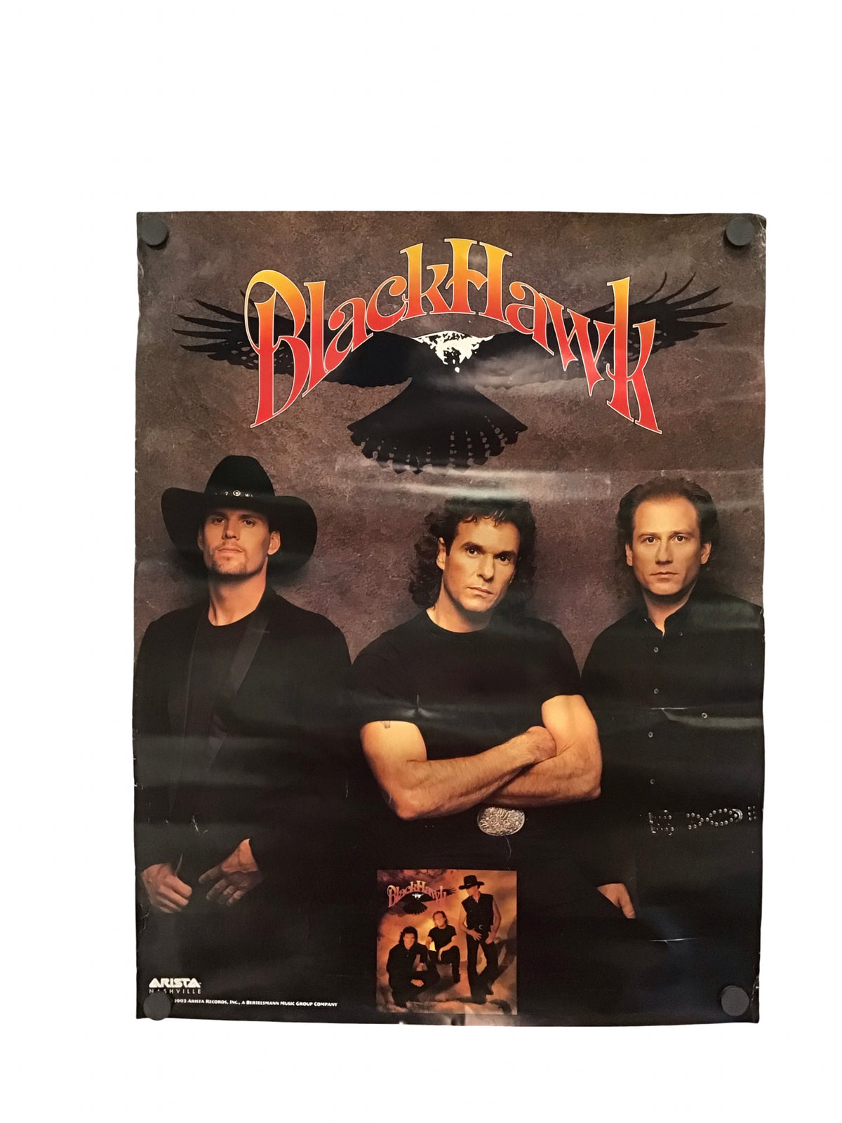 A vintage music poster for the band Black Hawk, featuring the band members in black attire against a dark background with a large red and yellow logo and an eagle graphic at the top.