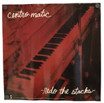 A square wall poster or print featuring a piano keyboard in warm reddish-brown tones, with the text 'centro-matic' at the top and 'fido the stacks' at the bottom.