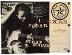 A vintage-style printed poster or sign featuring a black-and-white photo of a woman holding an electric guitar, with the text 'TEXAS SUGAR', 'STRAT MAGIK' on a cream background with printed lines for writing.