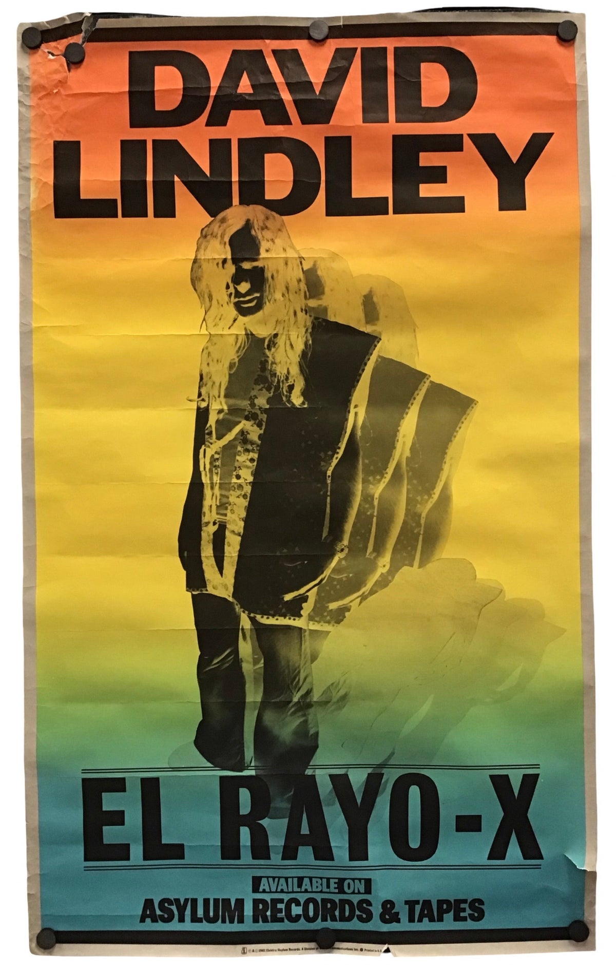 A vintage-style David Lindley El Rayo-X poster or print with a yellow-to-blue gradient background, large black text, and a central stylized figure, photographed against a plain light background.