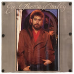 A square metal wall plaque featuring a printed portrait of country music artist Earl Thomas Conley, with his name in cursive script across the top and four black mounting screws at the corners.