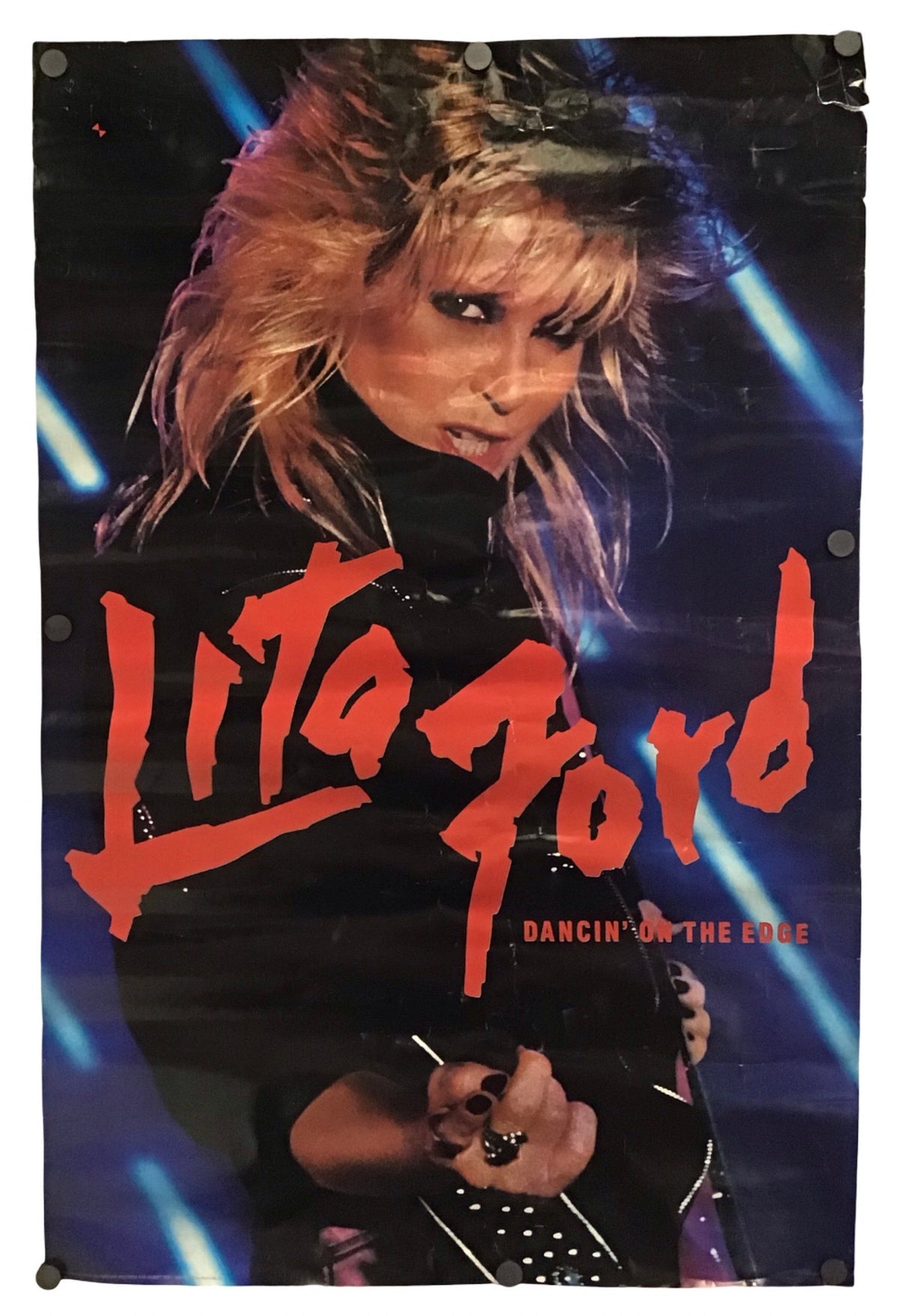 A vintage Lita Ford concert poster for 'Dancing on the Edge' featuring a photo of her on stage with bright red text and blue stage lights, shown against a plain white background.