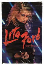 A vintage Lita Ford concert poster for 'Dancing on the Edge' featuring a photo of her on stage with bright red text and blue stage lights, shown against a plain white background.