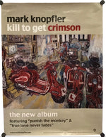 A printed album poster for Mark Knopfler's 'Kill to Get Crimson' hangs against a wall with black binder clips at the corners. The poster has a beige border with the artist's name and album title at the top and track text at the bottom, with a central painted scene showing several red motorbikes in a street setting.