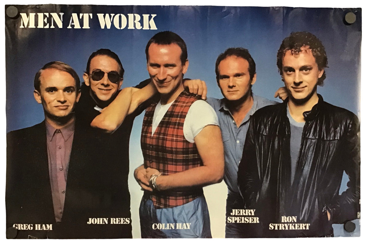A vintage band poster for 'Men At Work' featuring five men posing together against a blue gradient background, with the band name printed at the top and their names labeled at the bottom.