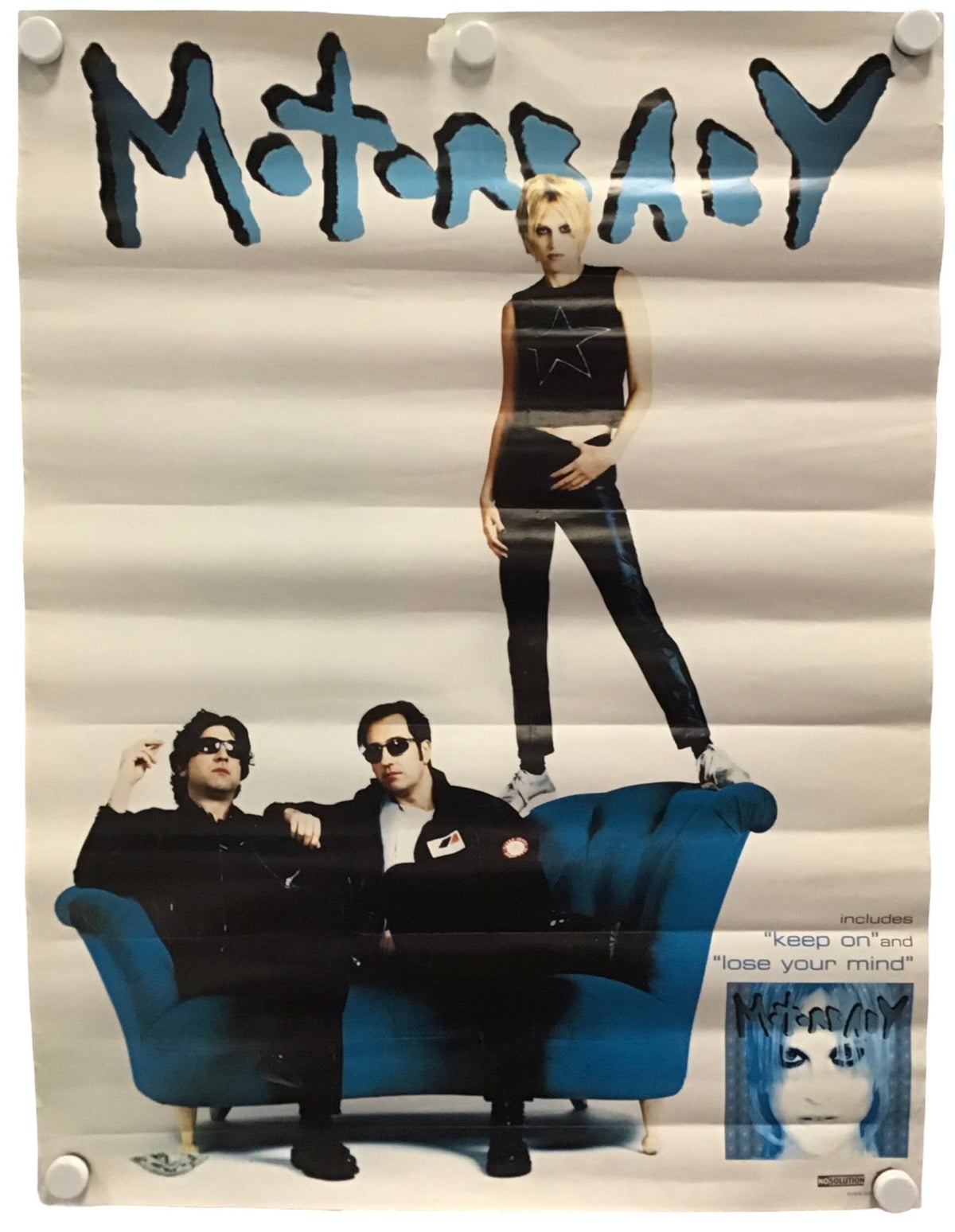A vintage-style Motorbaby band poster featuring the band members on a blue sofa, with a woman standing on the couch and the band name 'Motorhead' in large blue letters at the top. The poster is displayed against a white background with visible mounting clips at the corners.