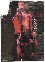 A distressed, torn poster print featuring a stylized graphic of a shirtless male performer in a red and black outfit holding a microphone, with visible mounting holes around the edges, set against a plain white background.