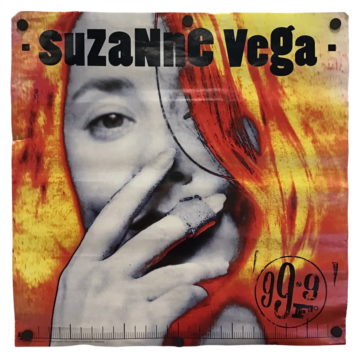 A square fabric bandana or scarf featuring a stylized graphic print of a woman's face with red hair, overlaid with orange and yellow flame-like patterns. The text 'suzanne Vega' is printed across the top, and '99.
