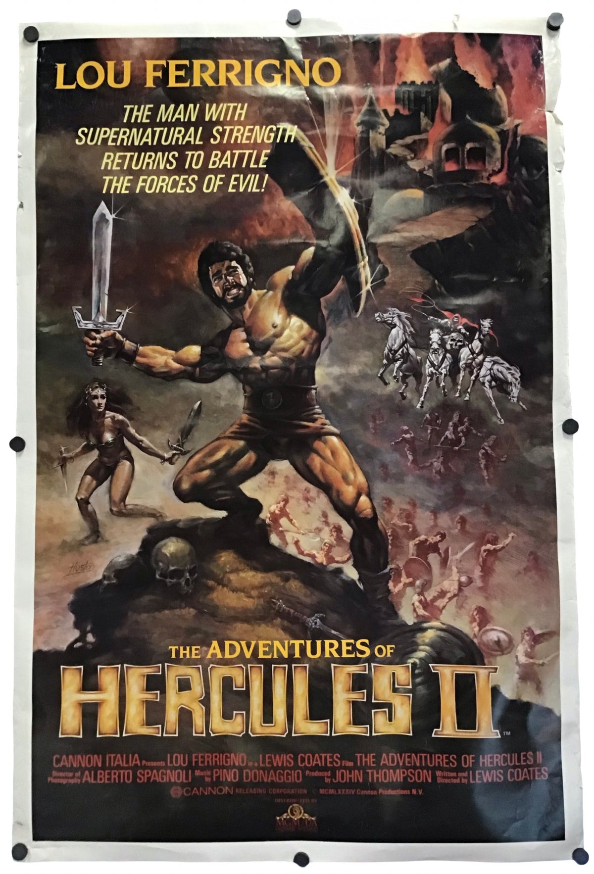 Vintage movie poster for 'The Adventures of Hercules II' featuring Lou Ferrigno as Hercules, shown hanging against a white wall with visible wall hooks around the edges.