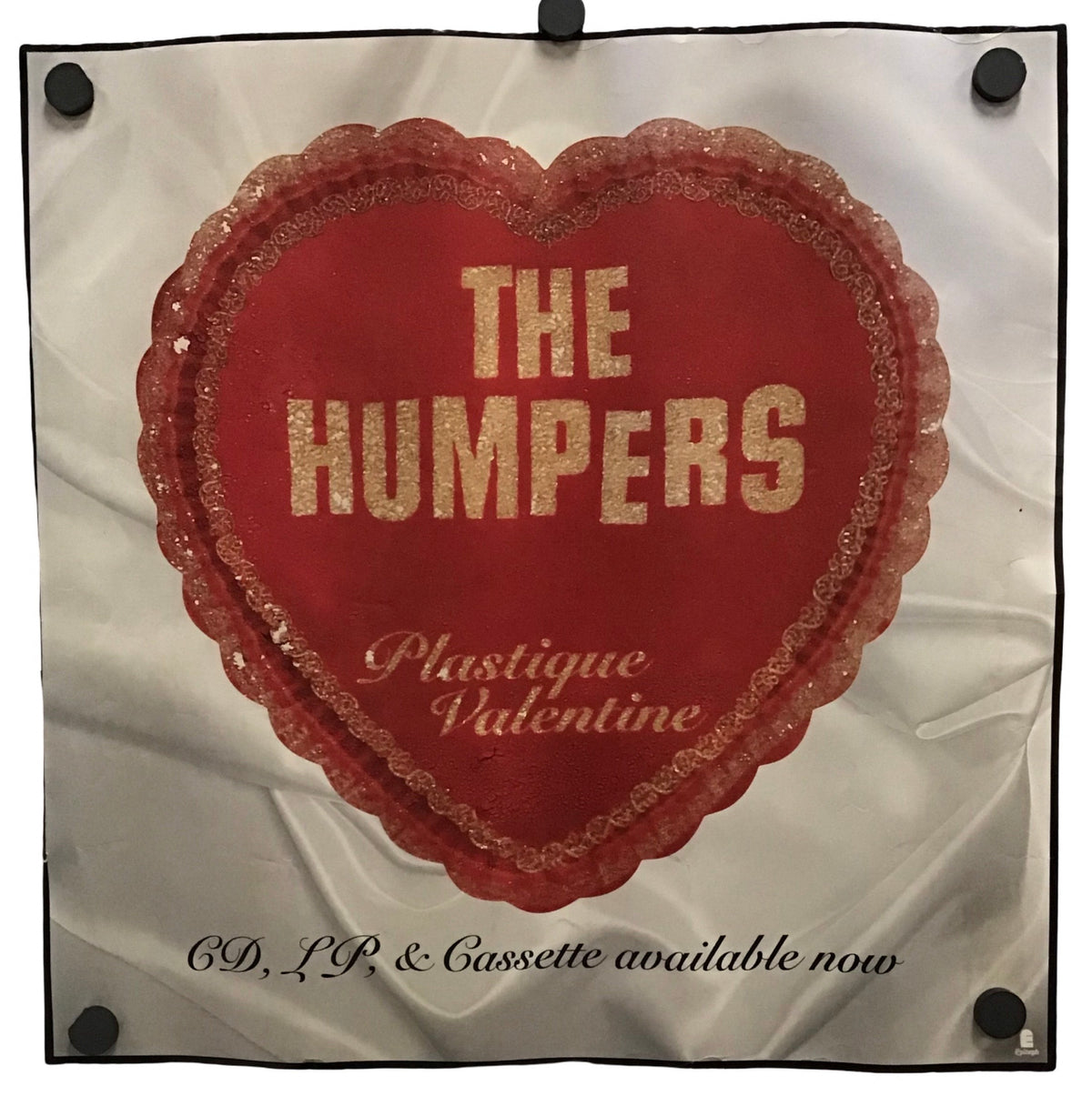 A square white fabric display or poster with a large red heart graphic in the center, bordered in black. The heart has sequins and reads 'THE HUMPERS' in gold letters, with 'Plastique Valentine' below.