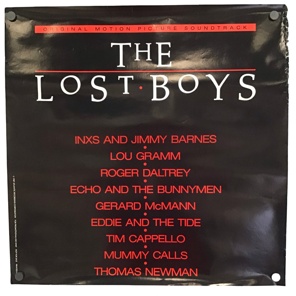 The Lost Boys original motion picture soundtrack vinyl record cover, featuring a black background with white and red text, photographed against a white background.