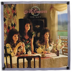 A square wall tapestry featuring the album cover art for 'The Gift' by the band McCarters. The tapestry is displayed flat against a white background, secured with four black grommets in the corners.