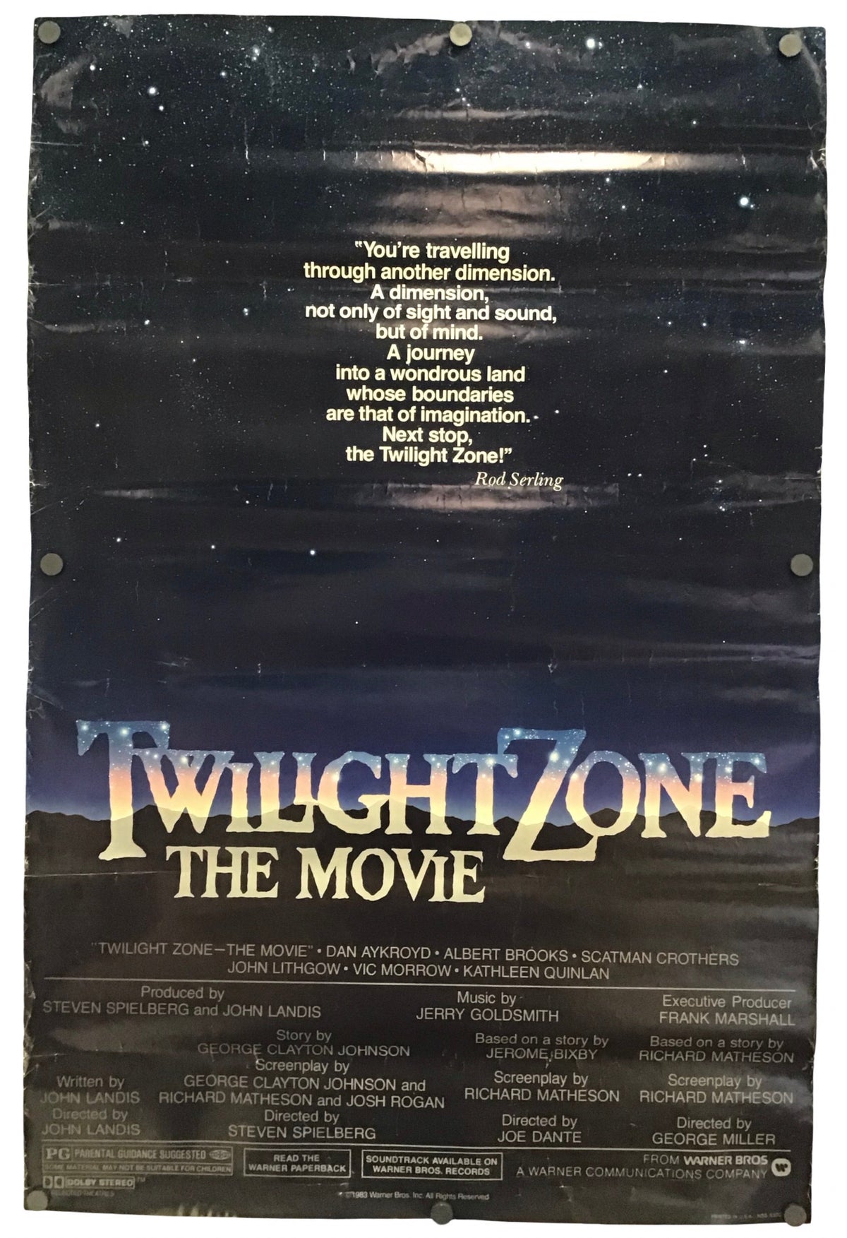 A vintage movie poster for 'Twilight Zone The Movie' with a dark starry sky background, large gold title text, and credits at the bottom, photographed flat against a light neutral background.