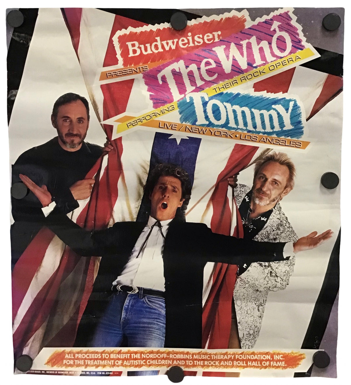 A vintage Budweiser 'The Who Tommy' concert poster mounted on a white wall with black binder clips. The poster features the band members in front of a stylized Union Jack background with bold multicolored text.