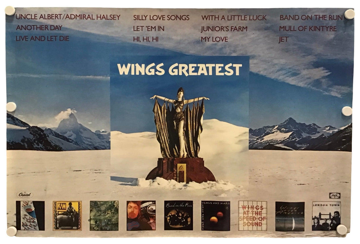 A vintage-style music poster for Wings Greatest, featuring a snowy mountain landscape, a central statue, and multiple album cover thumbnails along the bottom. The poster is displayed against a plain white background.