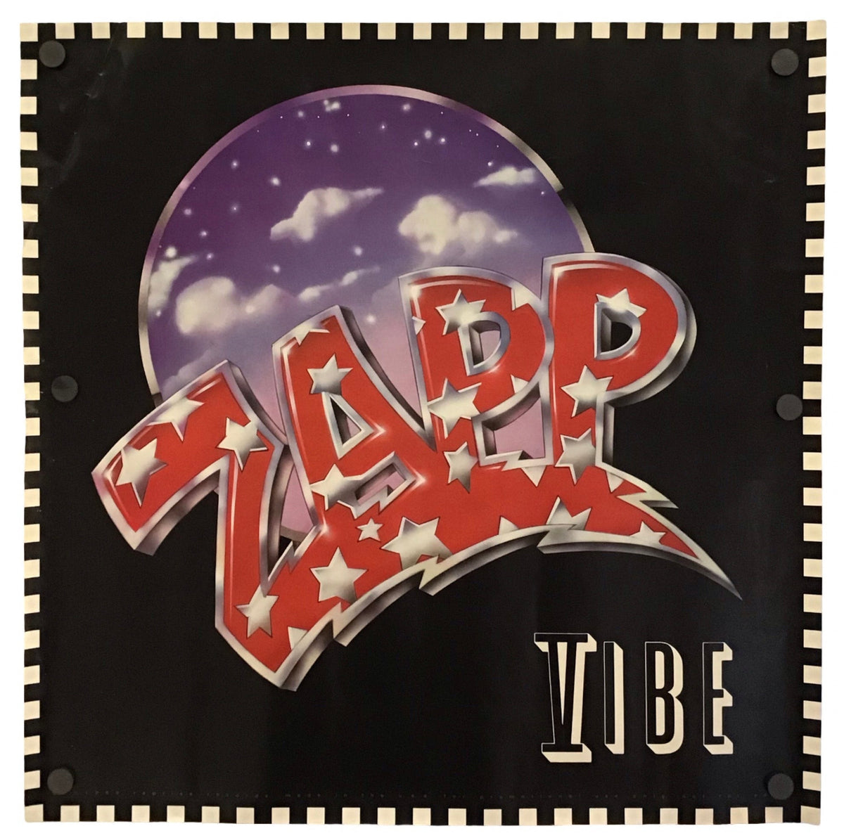 A square black wall banner or flag featuring the band name 'ZAPP' in large red lightning-bolt letters with white stars, set against a purple moon graphic, and 'VIBE' in beige text below. The banner has a black border with beige zigzag accents and is photographed flat against a white background.